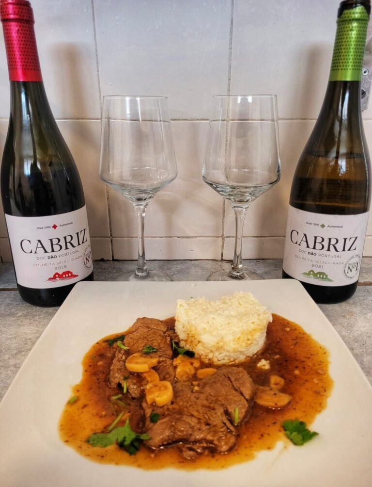 Prato de carne ao molho de vinho com arroz e taças de vinho